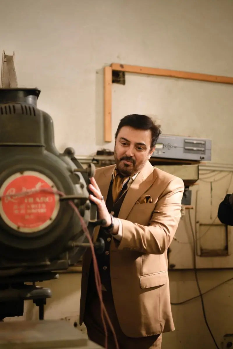 Agha Talish vintage black film projector with red label and metallic accents for luxury pakistani groom wear displays