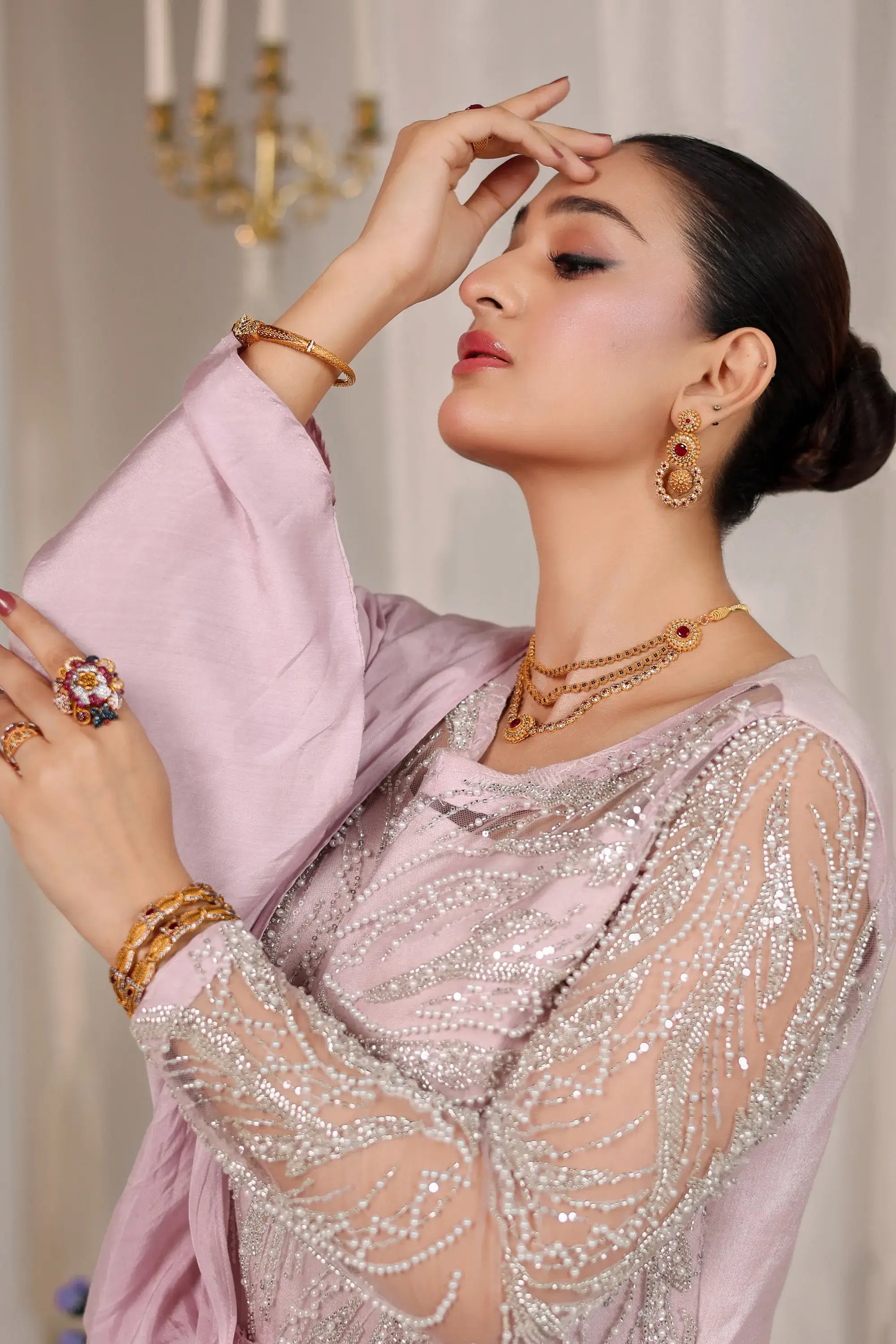 A woman wearing blush opulence soft blush pink sheer blouse with intricate silver beadwork by ahsan tariq