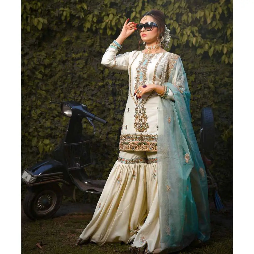 Elegant cream and teal embroidered pakistani salwar kameez with intricate gold detailing in a meticulously crafted three-piece silhouette