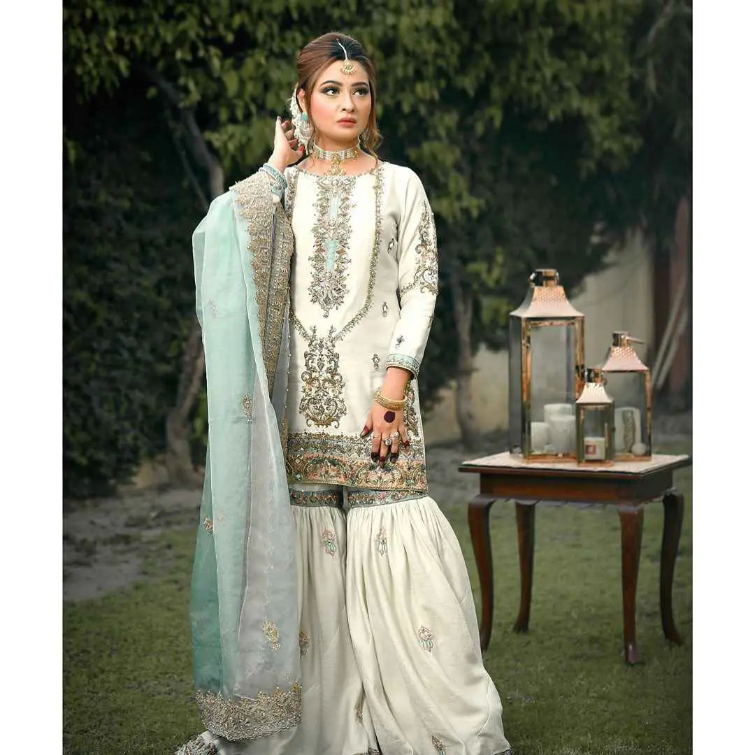 Elegant ivory and mint green meticulously crafted three-piece pakistani salwar kameez with gold threadwork for festive wardrobe