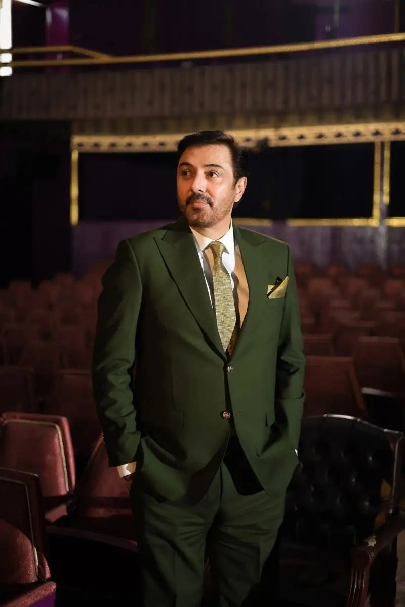 A man wearing a dark green three-piece suit with matching vest tie and gold pocket square in virsa-e-sitaaran edit 26