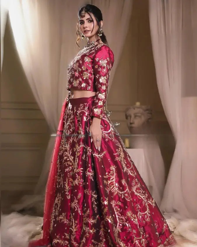 A rich maroon lehenga with intricate gold floral embroidery and a matching blouse from the romance fall winter collection