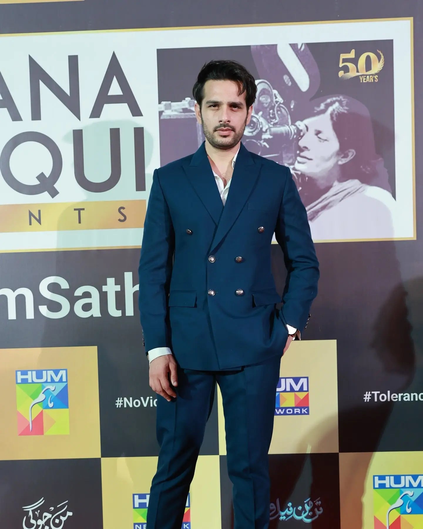 A man wearing an impeccably tailored double-breasted navy blue suit with silver buttons in the sapphire regency collection
