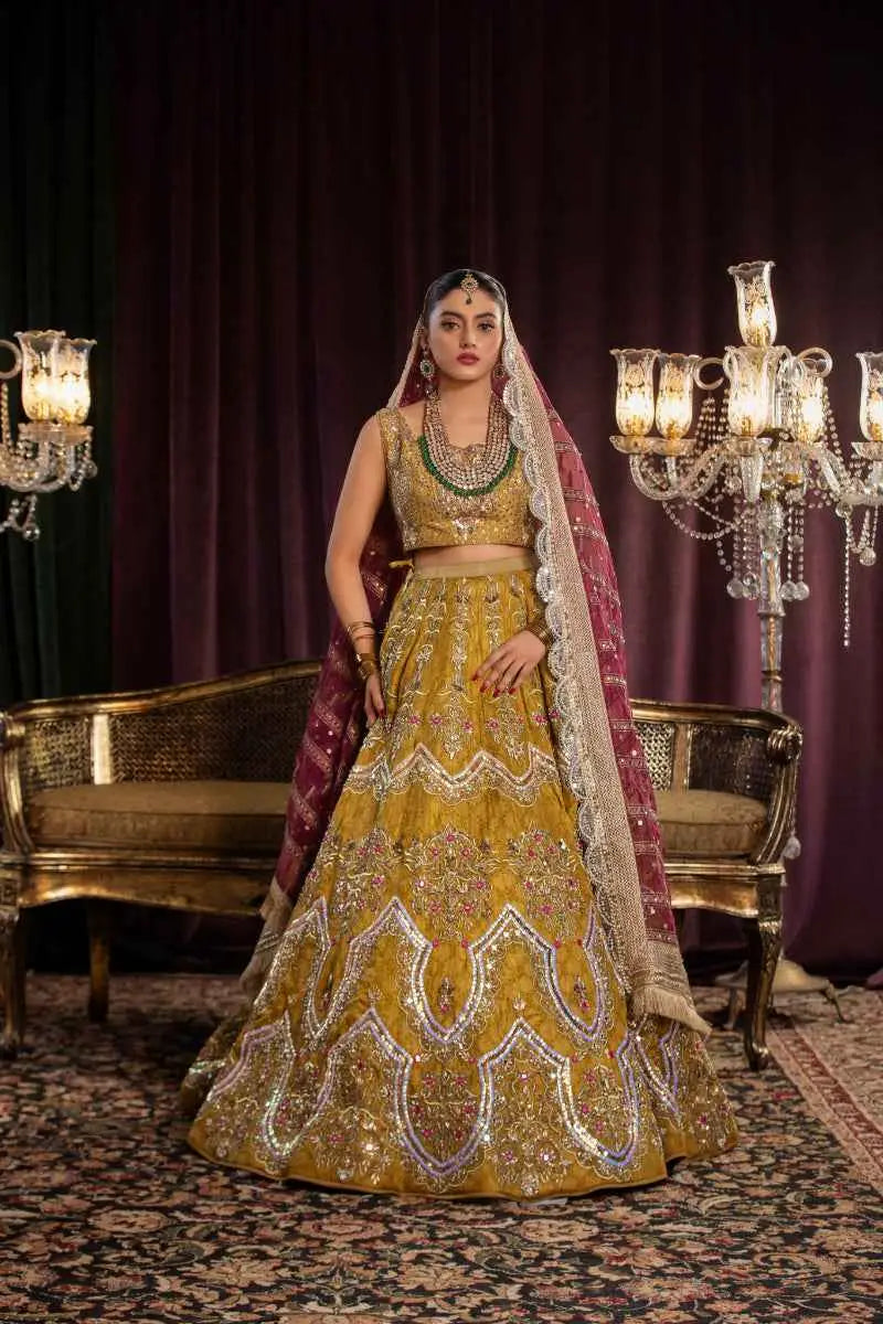 Golden lehenga sila featuring architectural chevron silver and purple embroidery paired with matching crop top and maroon dupatta