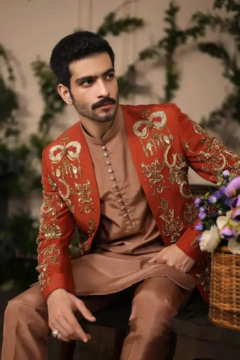 A rich red wazir khan jacket embroidered with intricate gold threadwork and ornate bow designs