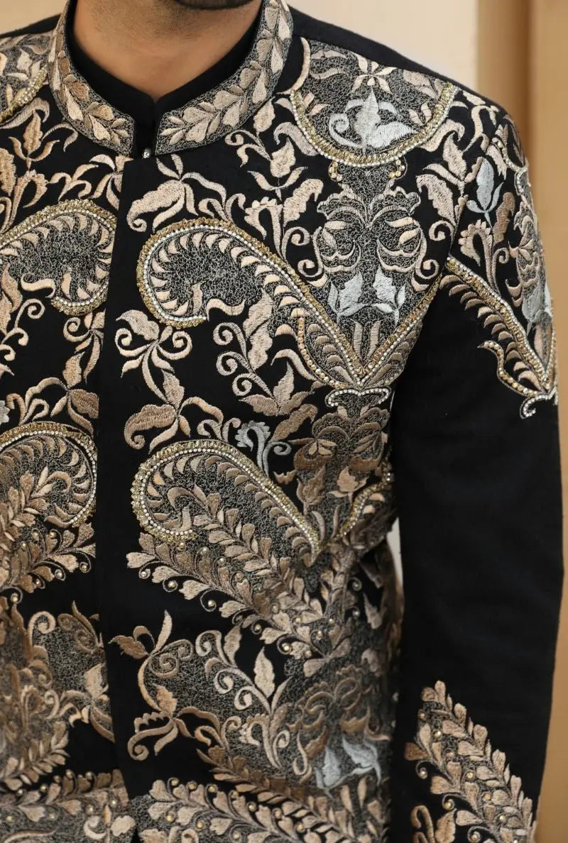 Black embroidered prince coat with intricate gold silver and beige paisley and floral patterns from aks raqeeb se collection by ahsan tariq