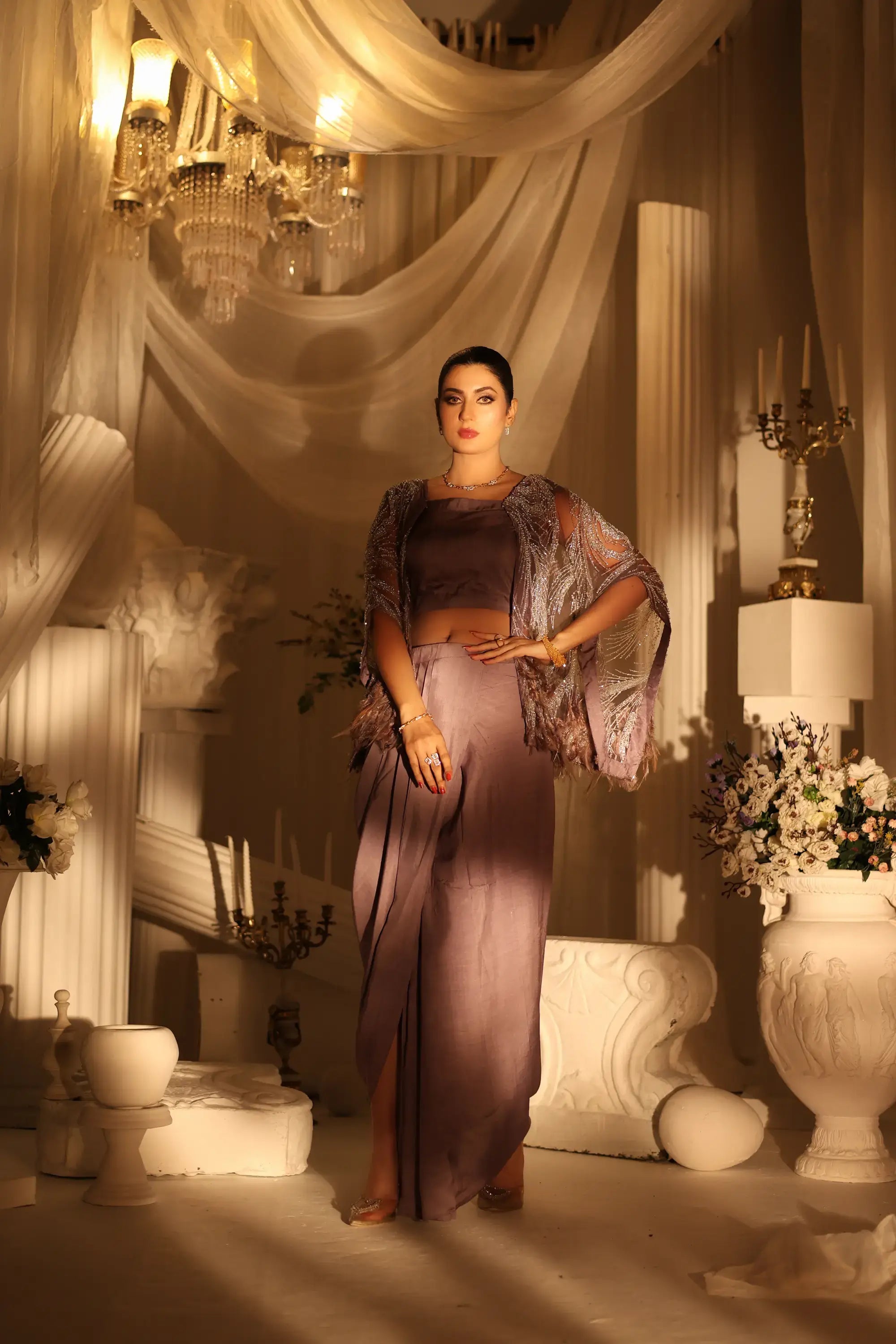 A woman wearing a lavender satin saree with a sheer embellished capelet in the amara drape ensemble