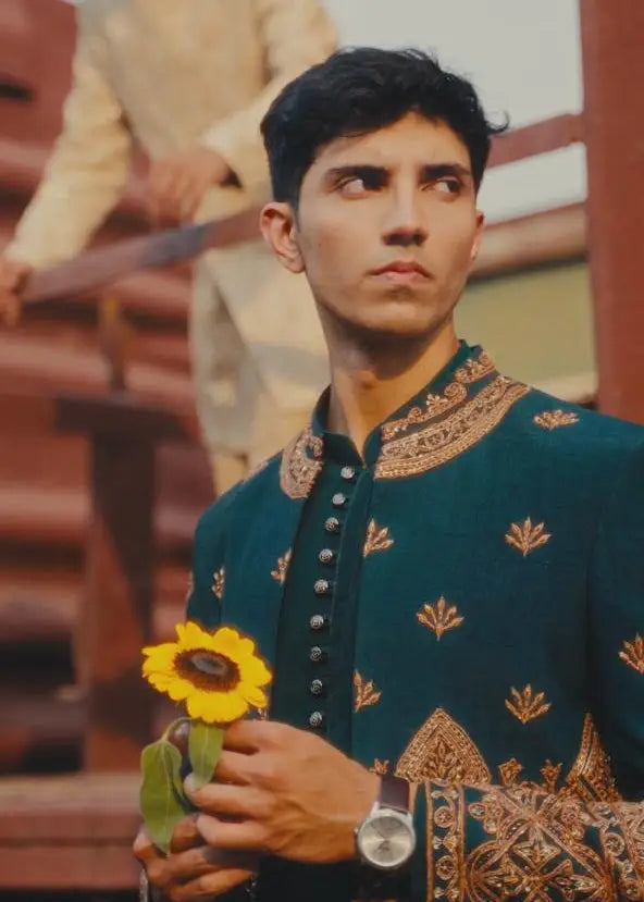 A vibrant yellow sunflower with green leaves held gently in hand representing Bagh-e-Zar product