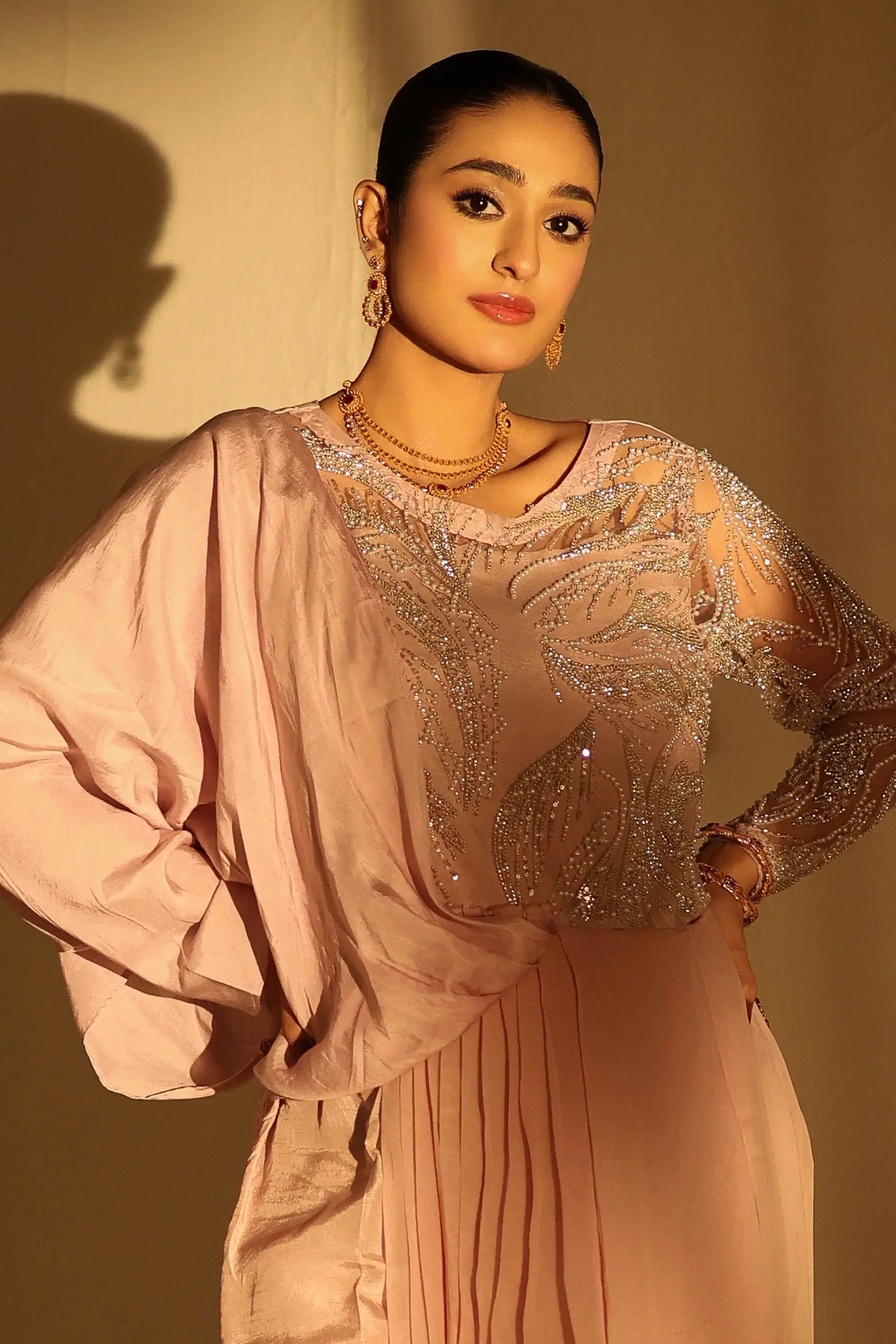 Blush opulence gown by ahsan tariq featuring soft blush pink long sleeves sheer sequined bodice and flowing fabric
