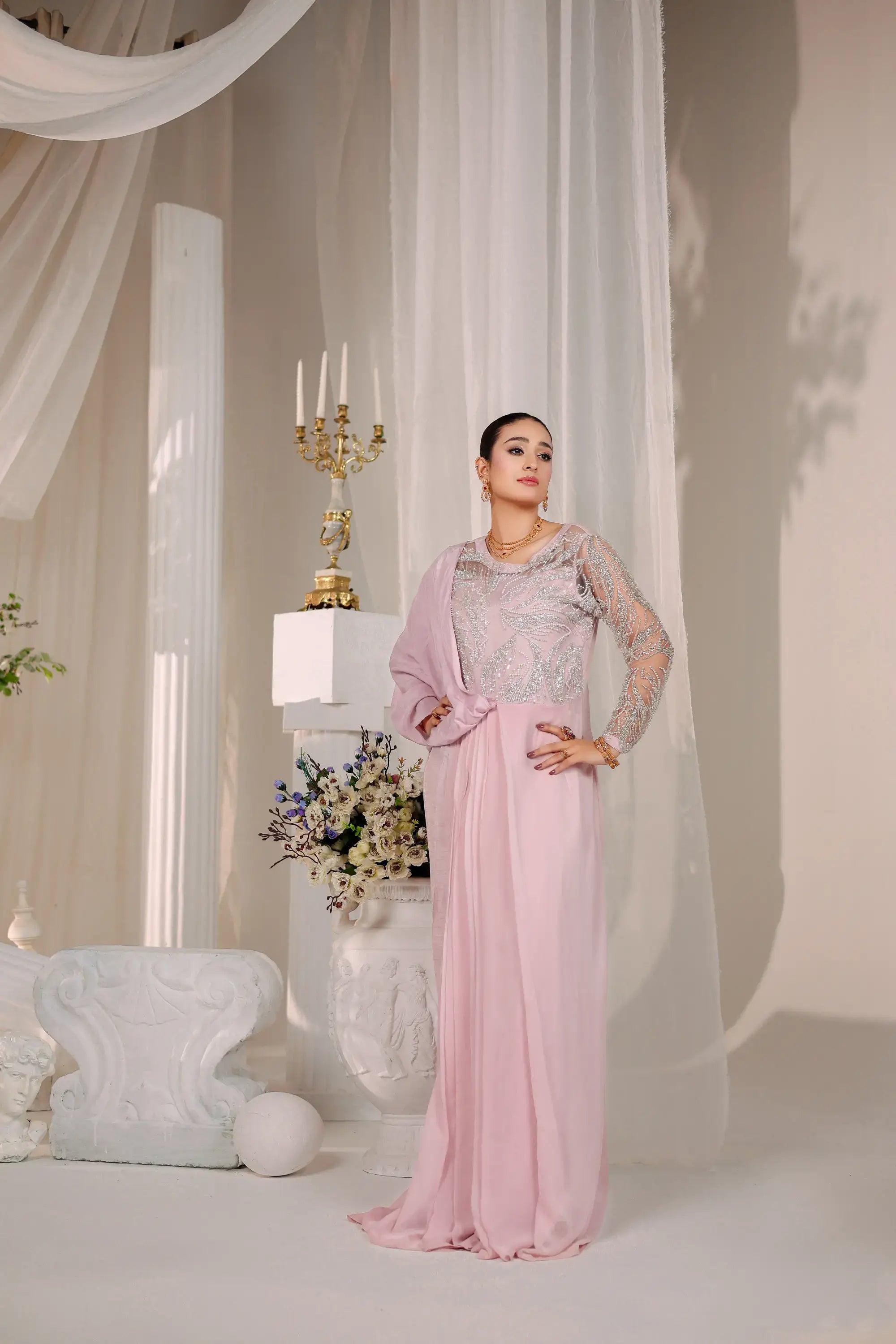 A woman wears blush opulence by ahsan tariq a soft blush pink gown with silver lace bodice and sheer sleeves