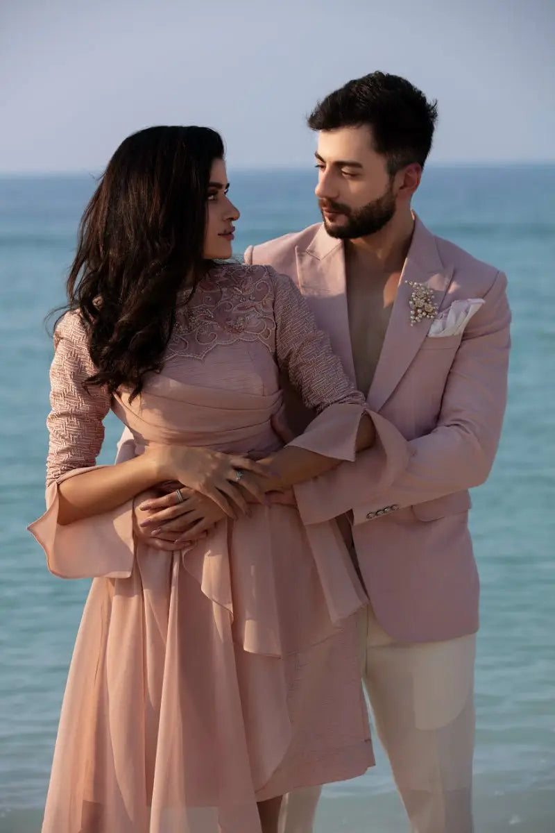 The dusk duo blush-pink lace dress by ahsan tariq features delicate flowing ruffled sleeves and skirt
