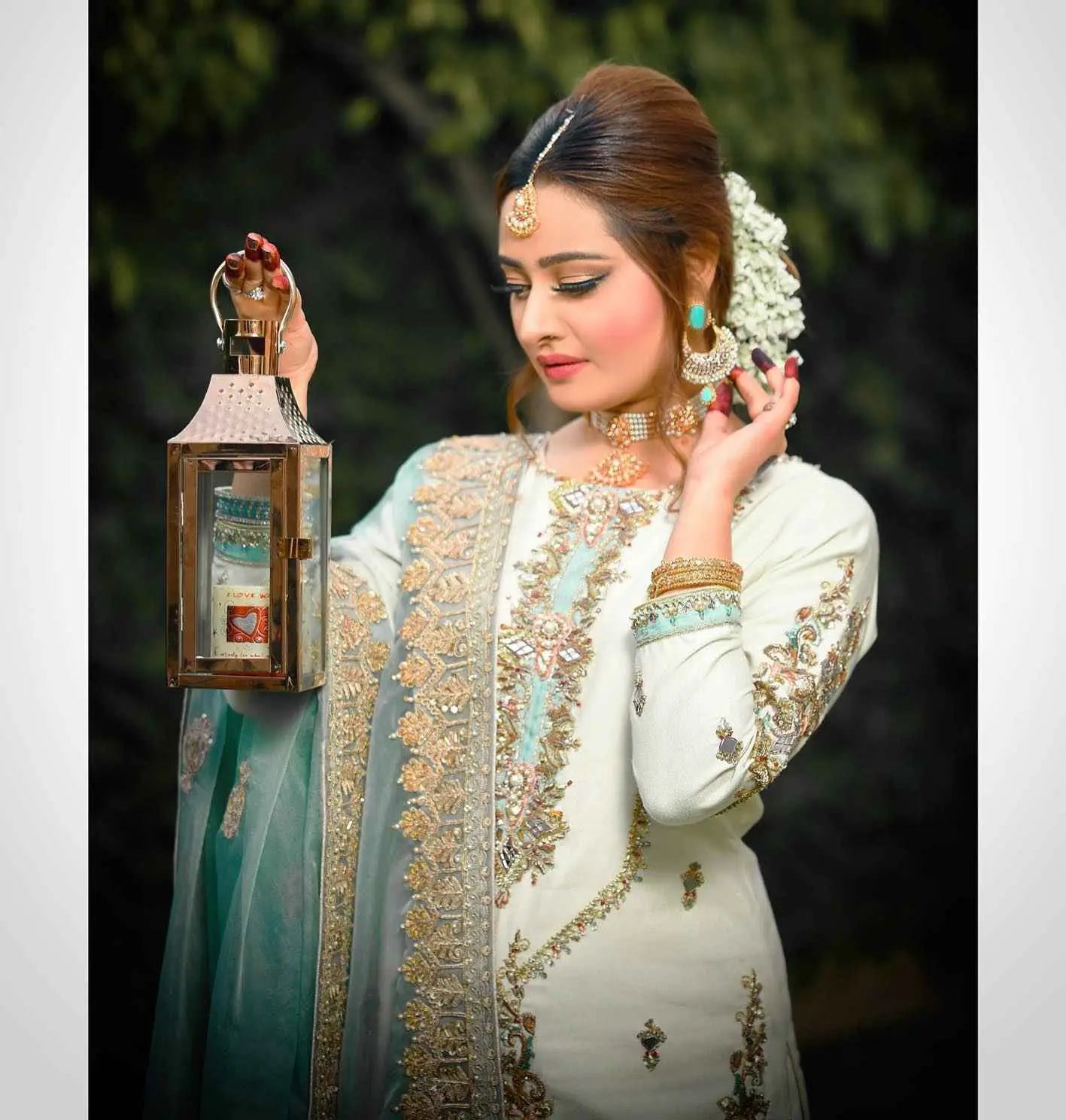 A woman holds a meticulously crafted three-piece brass lantern with intricate cut-out patterns for festive wardrobe use