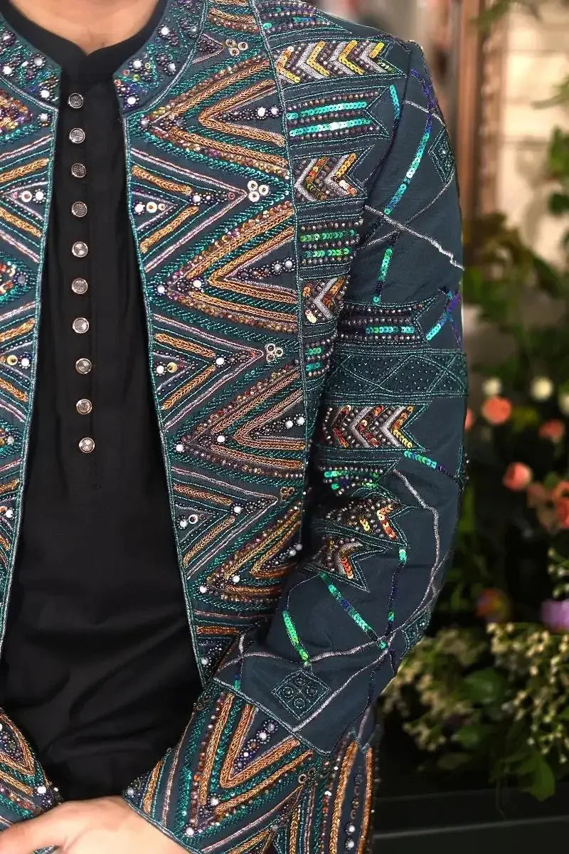 A dark teal blazer named Fakhar-e-Jahan with intricate gold green and silver sequin geometric patterns