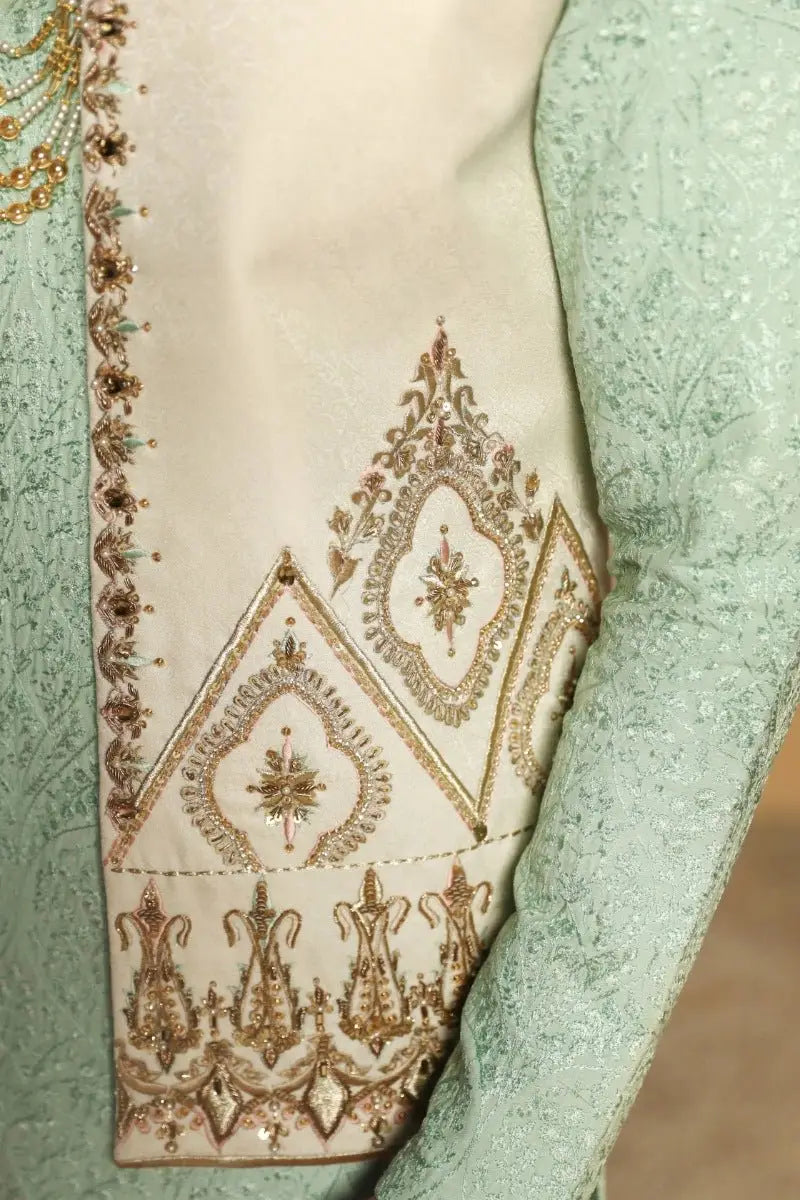 Cream-colored gulistan prince coat by ahsan tariq with intricate gold and metallic thread floral and geometric embroidery