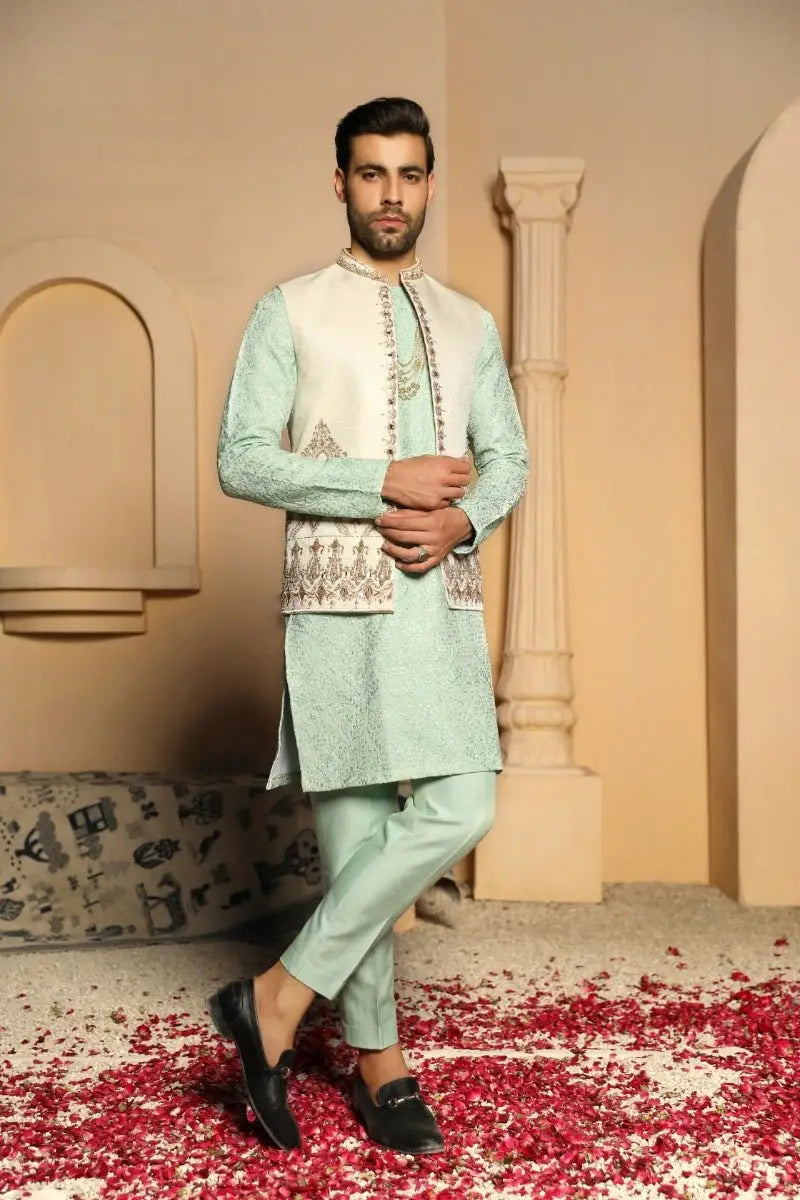 A man wearing a light mint green embroidered traditional indian prince coat from ahsan tariq gulistan collection