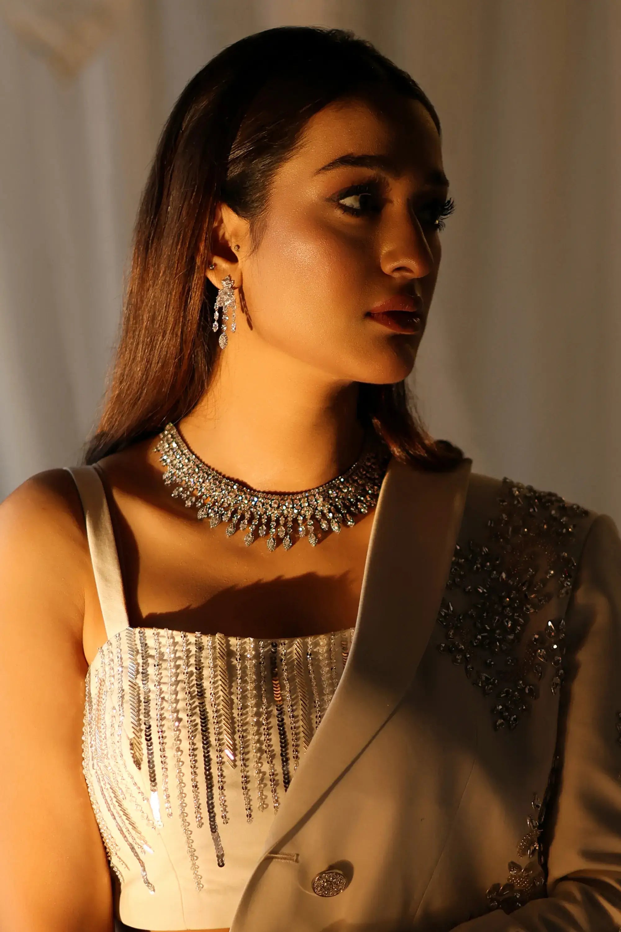 A sparkling silver choker necklace with intricate diamond-like embellishments and fringe details for formal wear by ahsan tariq ivory radiance