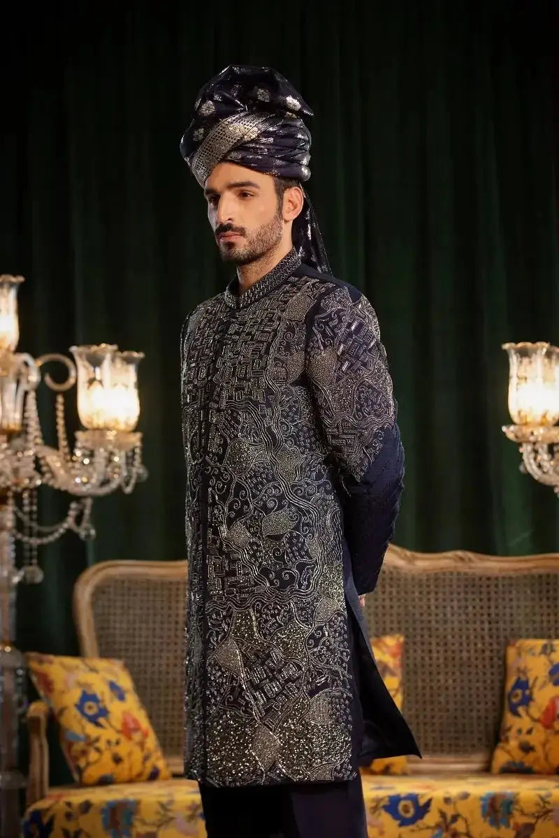 A man wears a dark navy raw silk sherwani with silver embroidery and a matching turban in mastaan collection