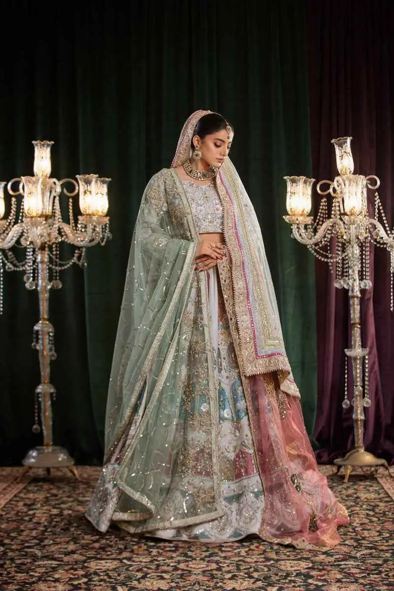 A woman wears the mehr-un-nisa ensemble bridal lehenga in soft powder blue with gold embroidery for a high-fashion aesthetic