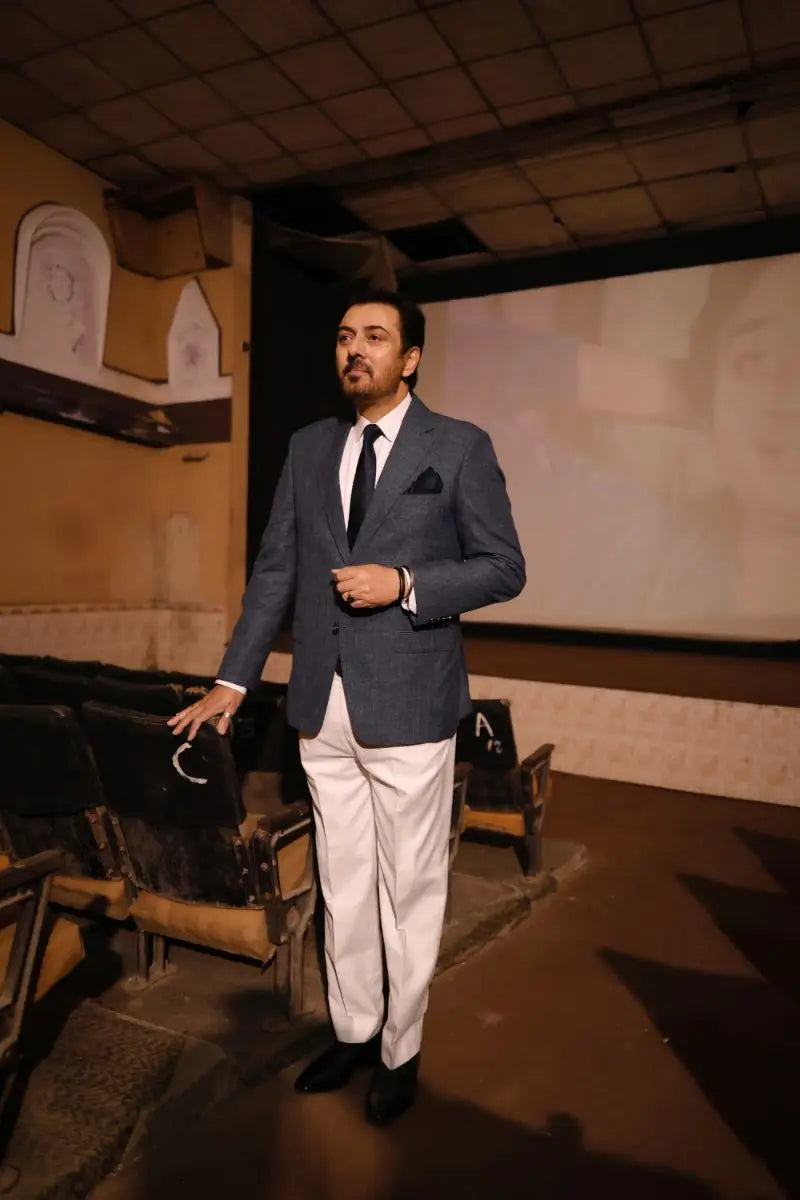 A man in a tailored navy blue suit jacket with white trousers and black dress shoes in Virsa-e-Sitaaran Edit 26