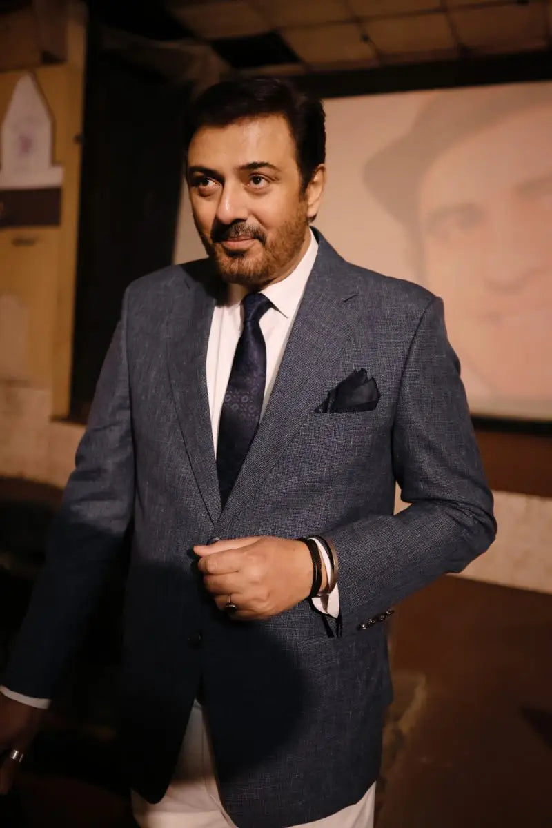 A man wearing a textured navy blue suit jacket with matching pocket square and tie from muhammad ali virsa e sitaaran edit 26