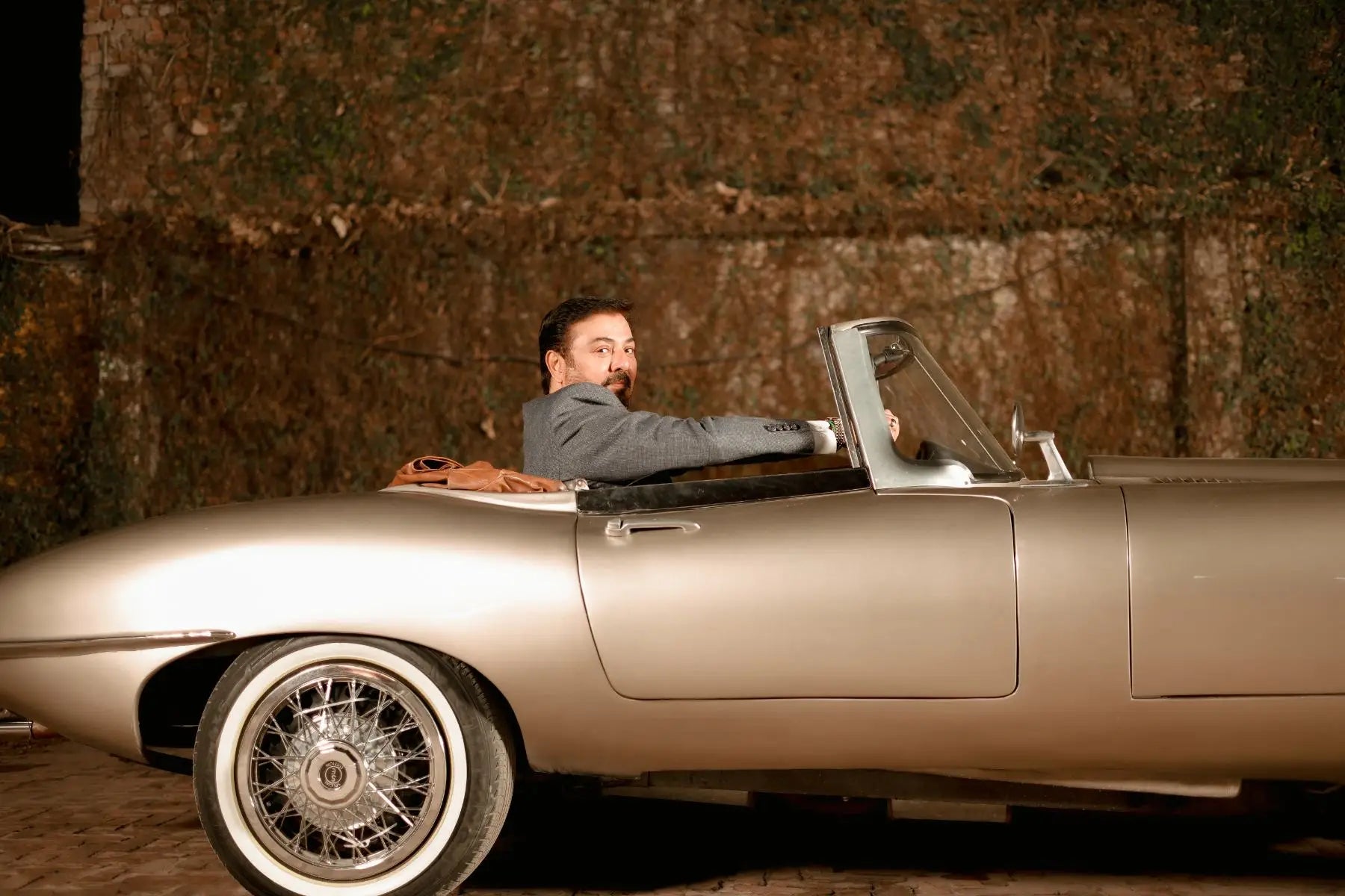Silver convertible sports car with chrome wire-spoke wheels and white wall tires in muhammad ali virsa-e-sitaaran edit26