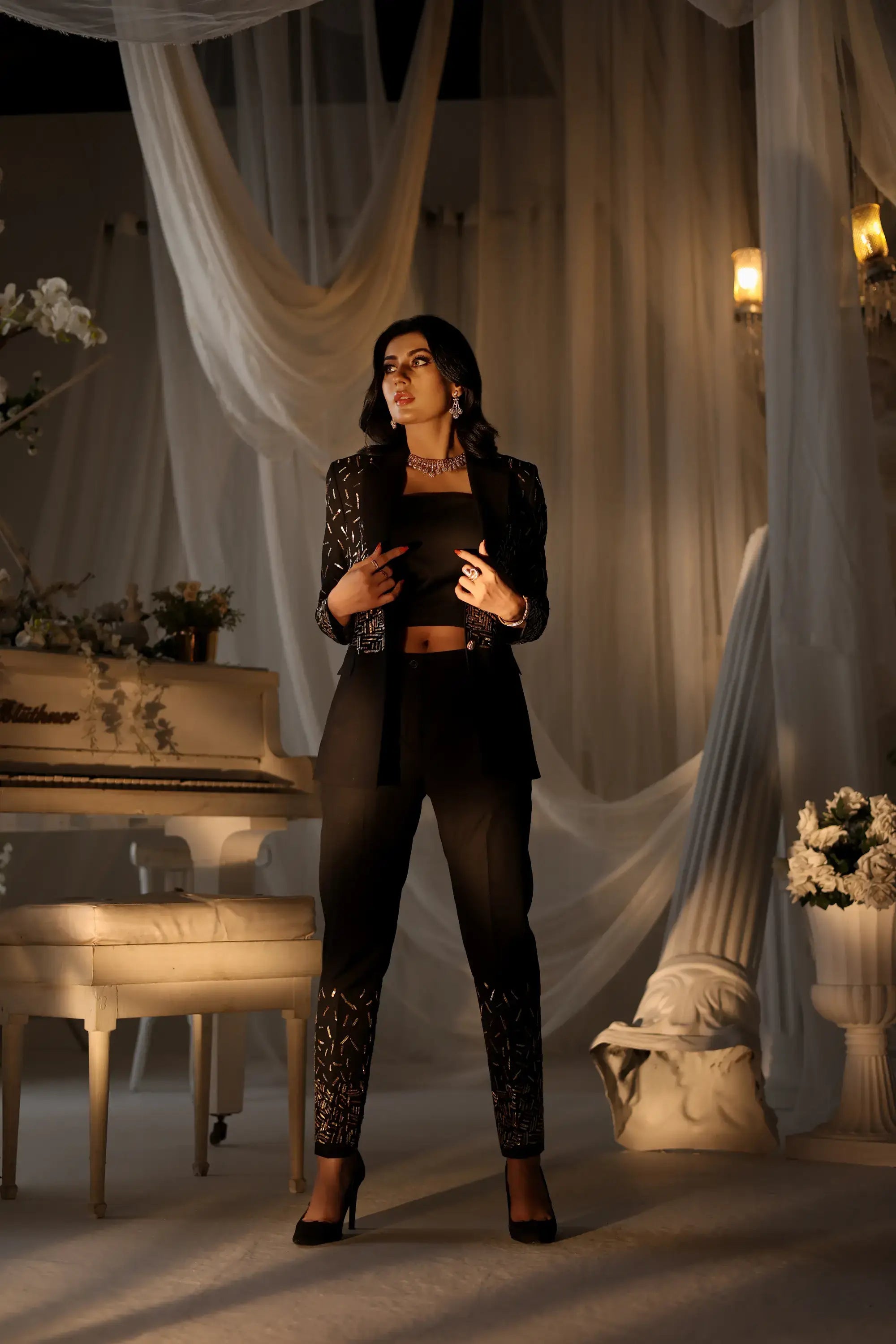 Black blazer with intricate silver embellishments and matching black pants with sequin cuffs in noir luxe ensemble