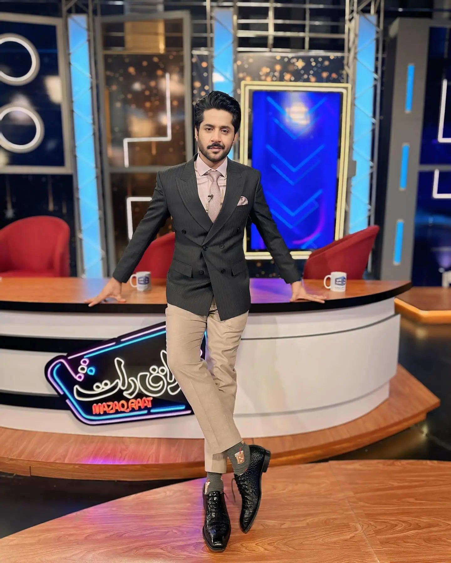 Man wearing onyx dark gray double-breasted blazer with beige trousers showcasing modern power dressing style