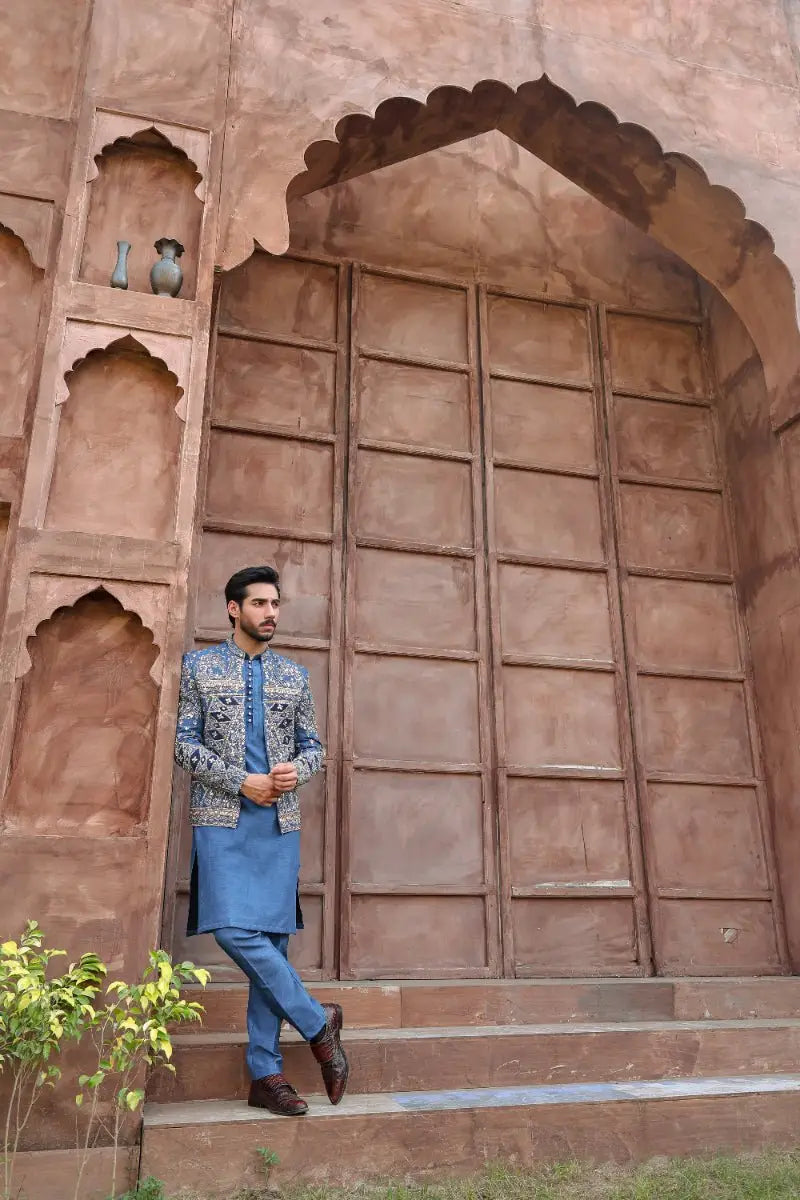 A man wearing a blue embroidered prince coat with silver threadwork from ahsan tariqs ishq collection QALB