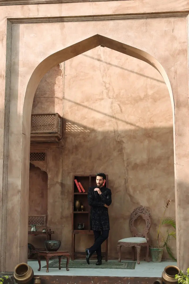 Ahsan Tariq QARA black patterned long-sleeved shirt from Ishq collection worn by man in rustic arched doorway