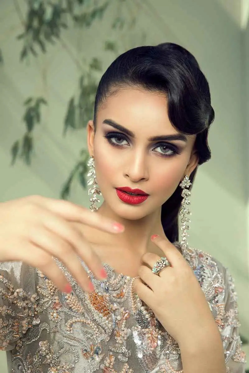 The woman wears a silver quicksilver gown with an intricate beaded mesmerizing blend by Ahsan Tariq