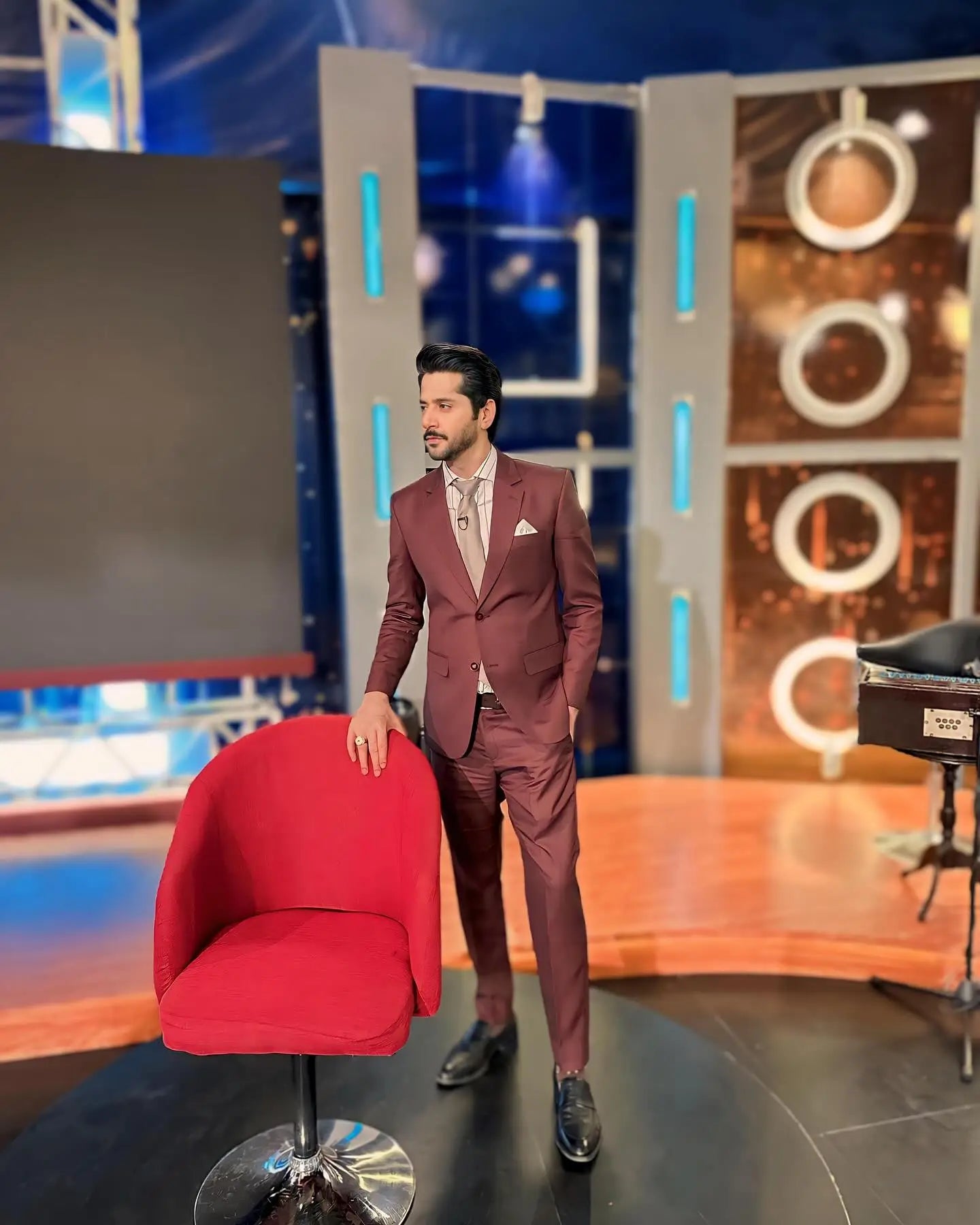 A vibrant red upholstered swivel chair with chrome base in royal mahogany by ahsan tariq