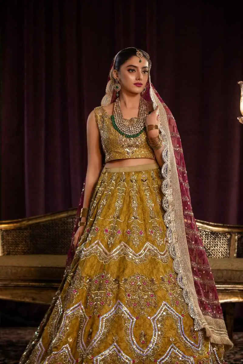 Golden lehenga sila features architectural chevron embroidery in silver and pink paired with matching crop top