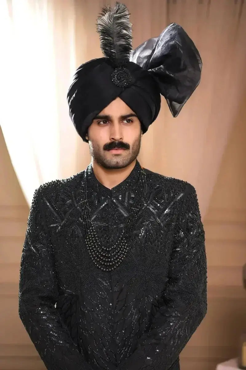 Black raw silk turban tajdar adorned with a feather and an ornate black bow for elegant wear
