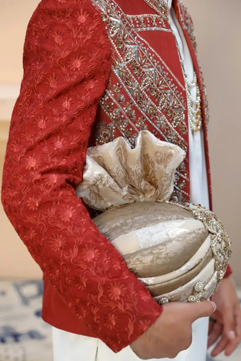 Cream-colored intricately embroidered turban with metallic gold floral motifs and decorative ruffled top by ahsan tariq