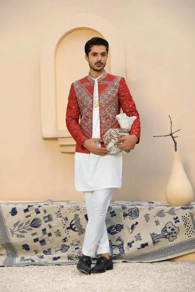 Red embroidered jacket by yashoot featuring intricate silver thread floral motifs designed by ahsan tariq